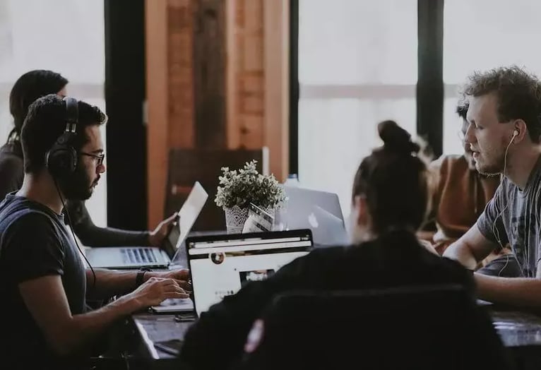 Personengruppe an einem Tisch bei einem Meeting - WhatsApp Unternehmen